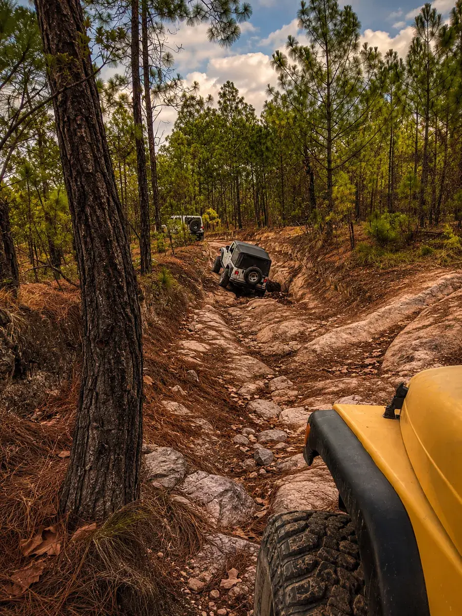 Vista desde un Jeep amarillo recorriendo un obstáculo rocoso